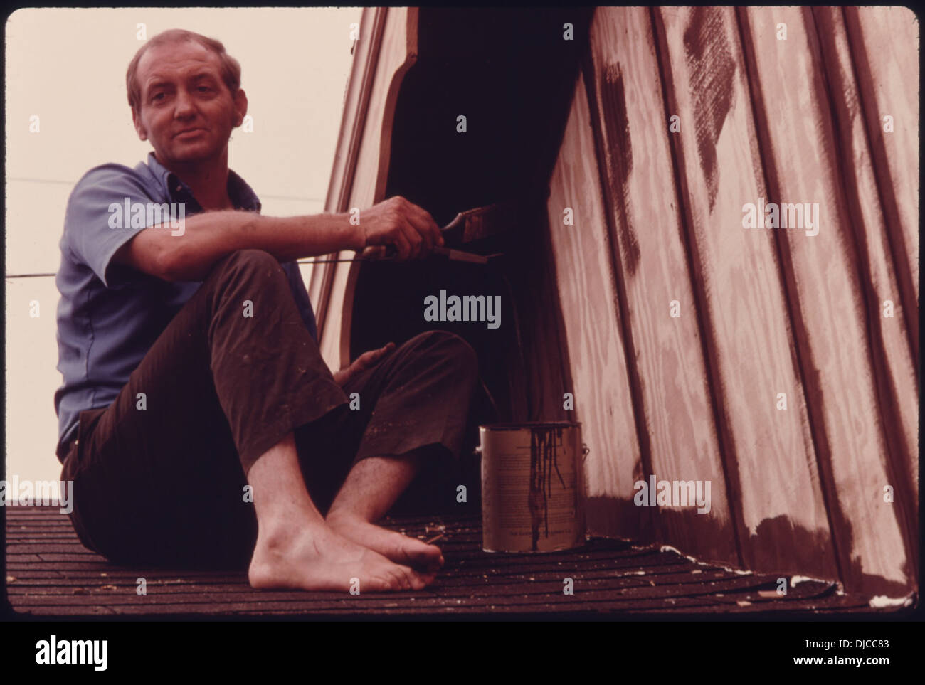 Lanier Chambers peint une partie de l’extérieur alpin nouvellement conçu de sa station-service récemment acquise à la périphérie de Helen, en Géorgie. Banque D'Images