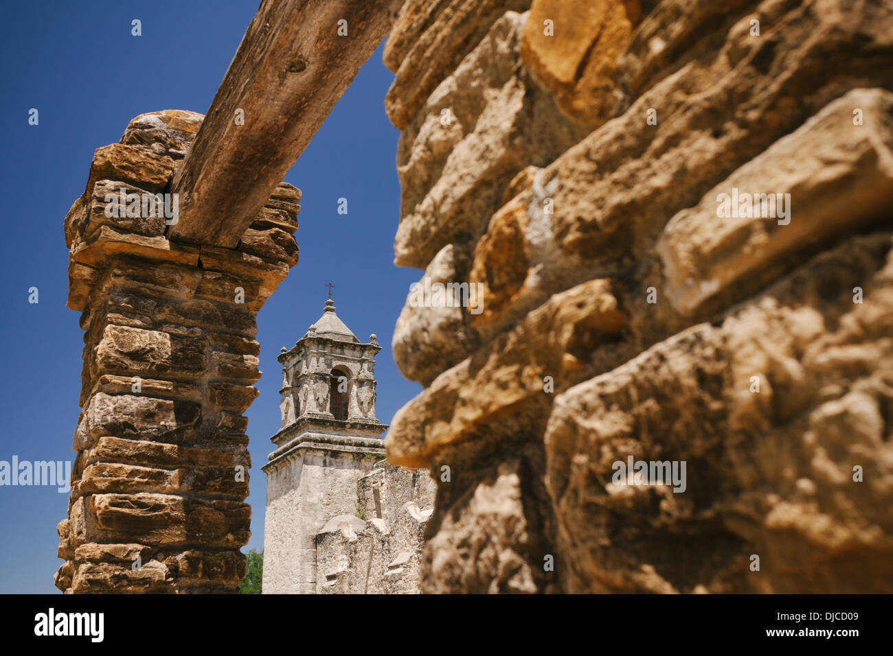 Le clocher de l'église Mission San Jose est encadrée par une ouverture dans un mur de pierre. San Antonio, Texas. Banque D'Images