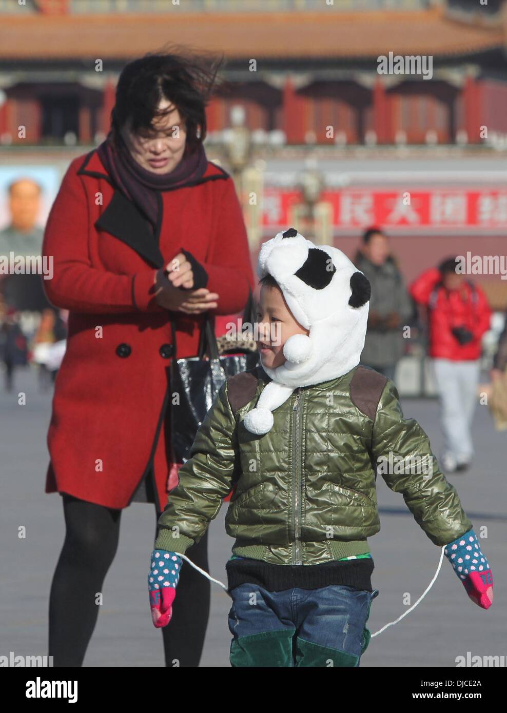 Beijing, Chine. 27 nov., 2013. Un jeune garçon tient chaud comme visiter la Place Tian'anmen à Beijing, capitale de Chine, le 27 novembre 2013. Un front froid a balayé le centre et l'est de la Chine, apportant des vents violents et du point de congélation de la température à Beijing mercredi. Credit : Xing Guangli/Xinhua/Alamy Live News Banque D'Images