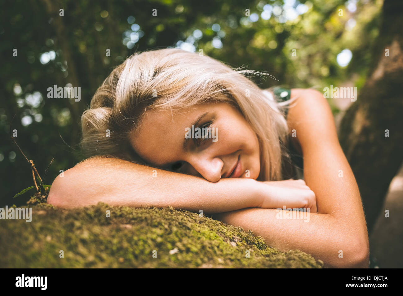 Content gorgeous blonde lying on trunk Banque D'Images