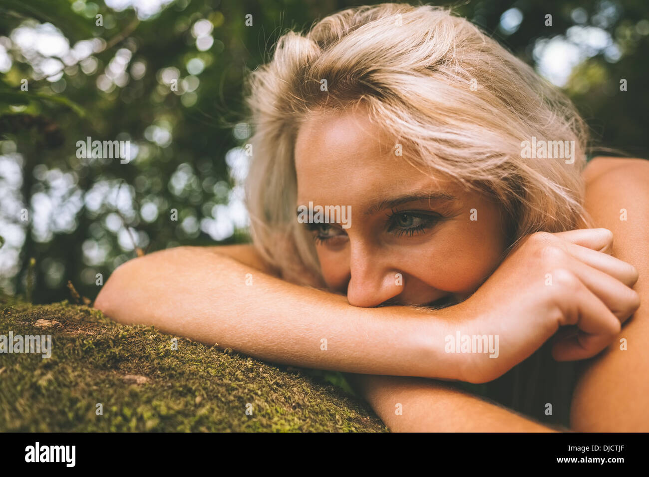 Happy gorgeous blonde lying on trunk Banque D'Images
