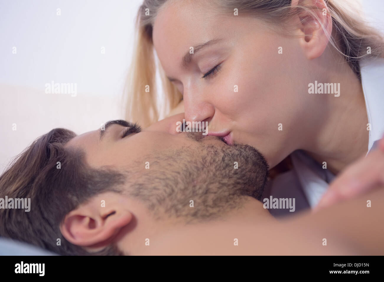 Cute blonde woman kissing her boyfriend Banque D'Images