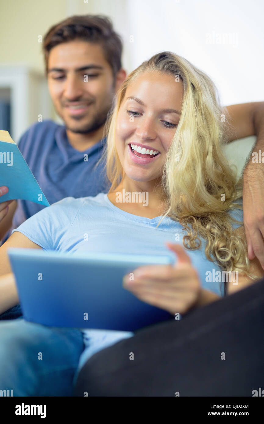 Rire couple reading et à l'aide d'une tablette Banque D'Images