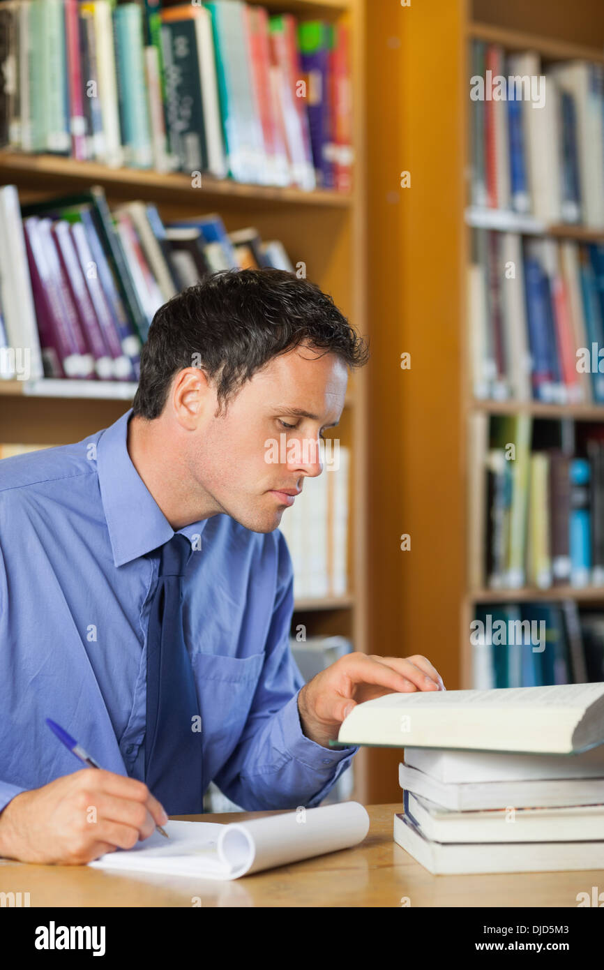 Bibliothécaire grave assis à 24 prendre des notes Banque D'Images