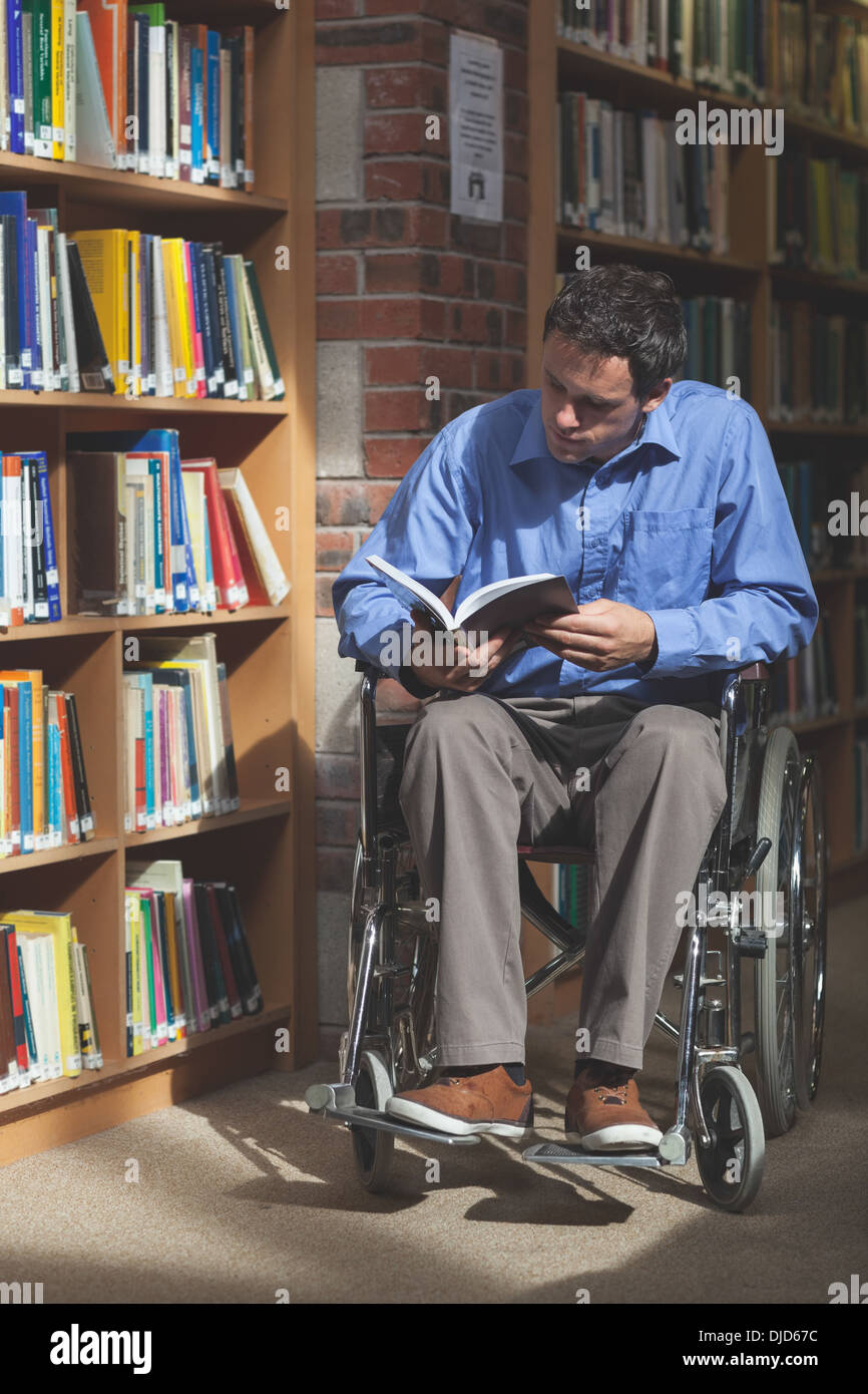 L'accent man in wheelchair reading a book Banque D'Images