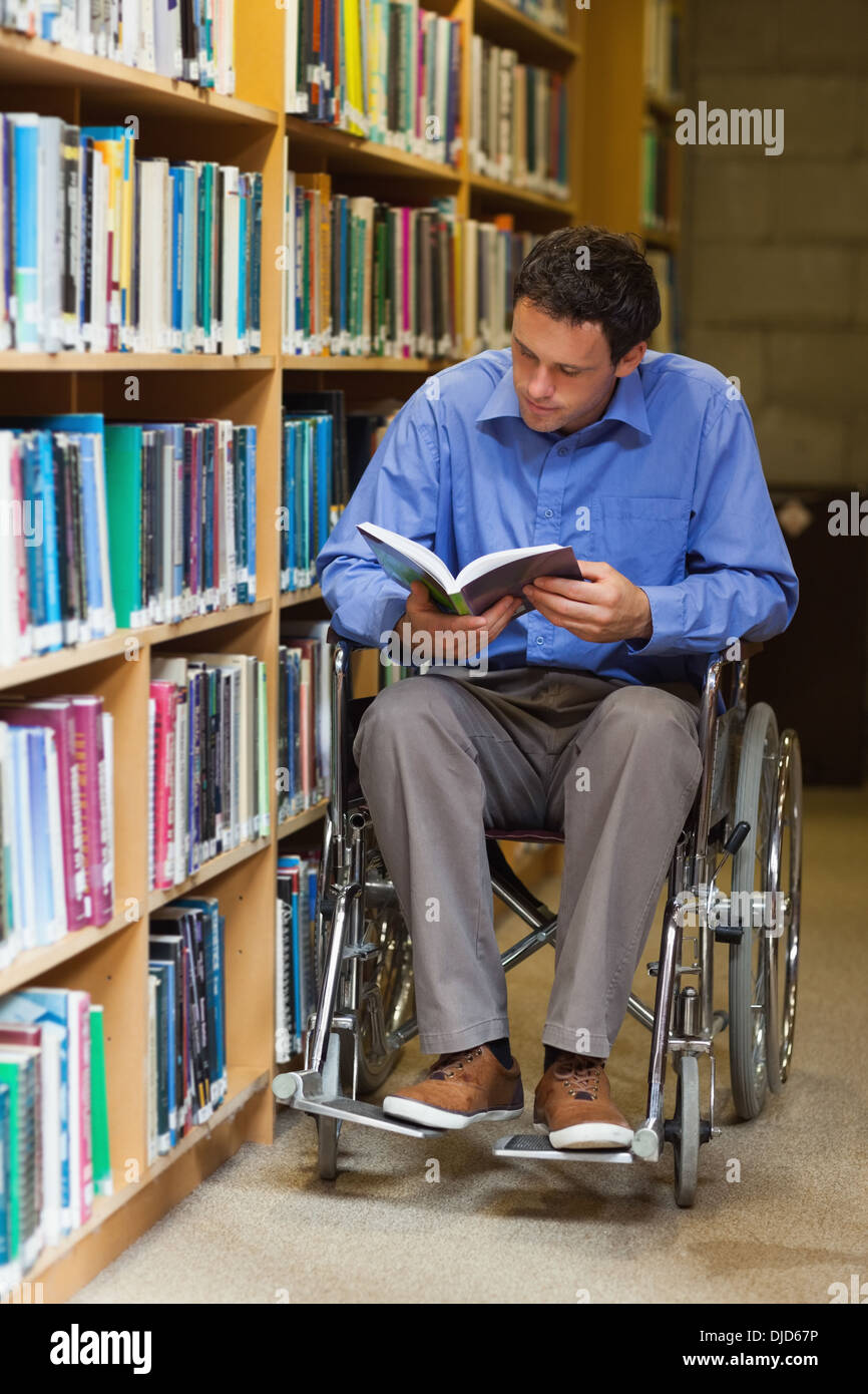 Concentrant man in wheelchair reading a book Banque D'Images