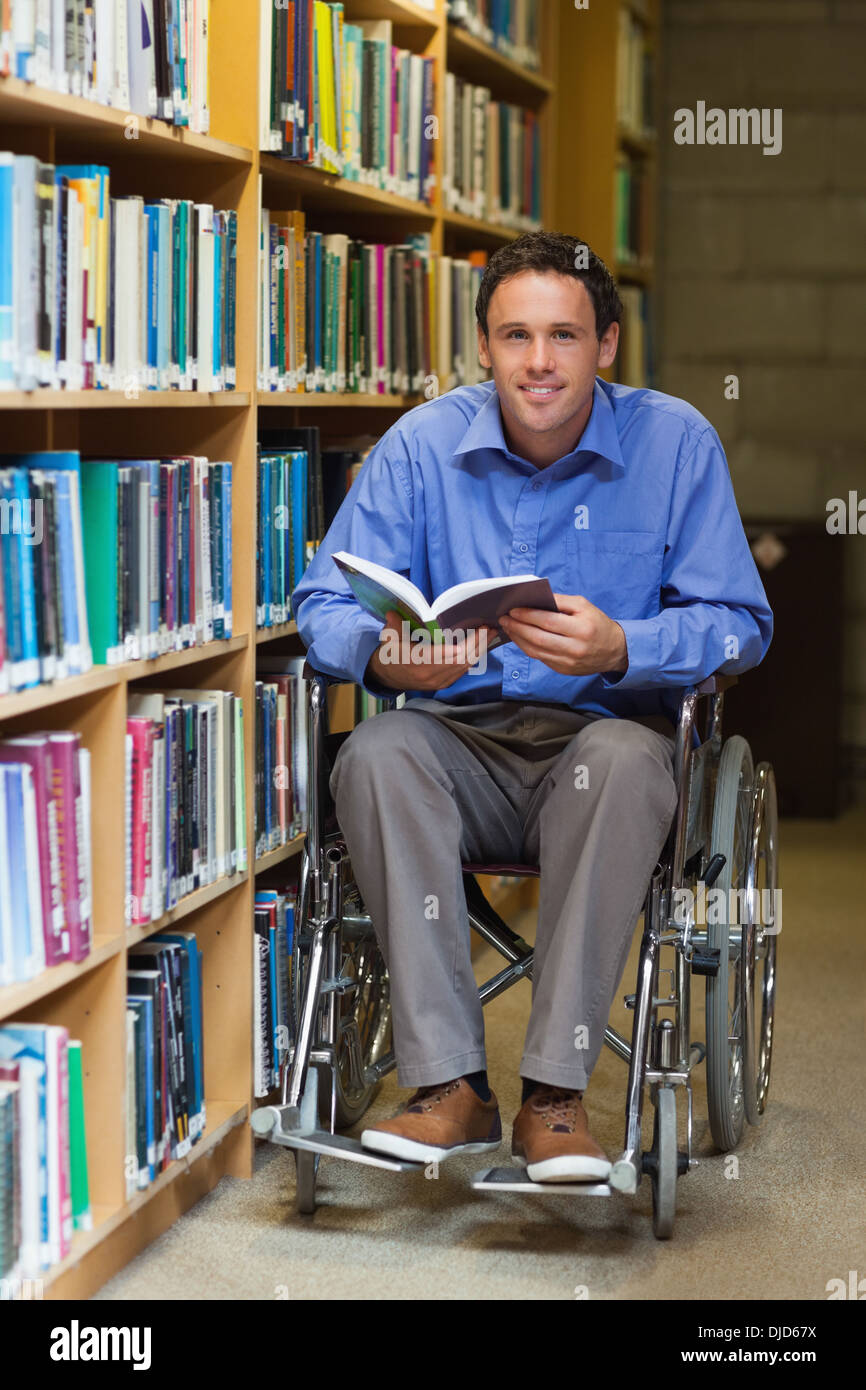 Happy man in wheelchair holding a book Banque D'Images