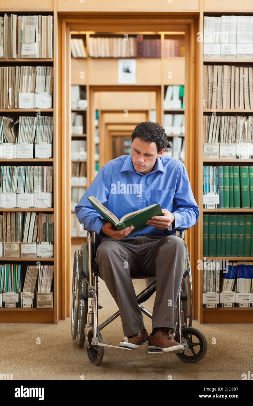 L'homme calme en lisant un livre en fauteuil roulant Banque D'Images