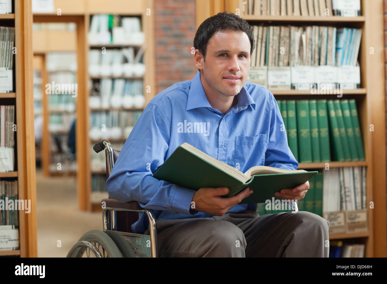 Content man in wheelchair holding a book Banque D'Images