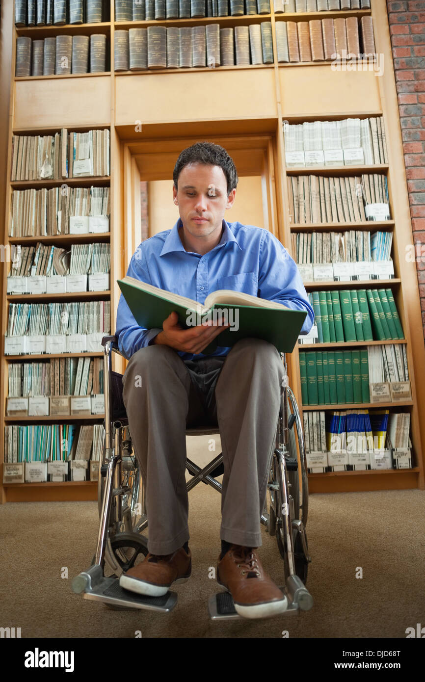 Calme man in wheelchair holding a book Banque D'Images