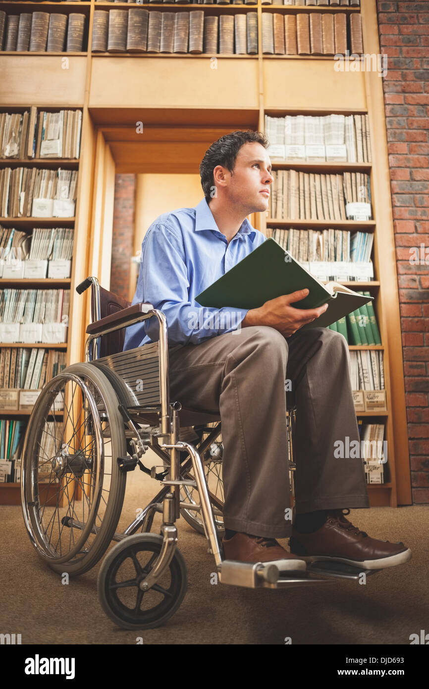 Rêver man in wheelchair holding a book Banque D'Images