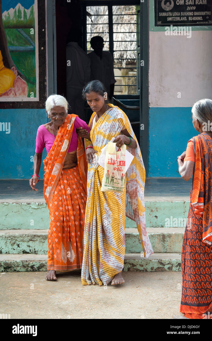 Vieille Femme indienne d'être aidé de Sri Sathya Sai Baba mobiles de proximité hôpital clinique. L'Andhra Pradesh, Inde Banque D'Images