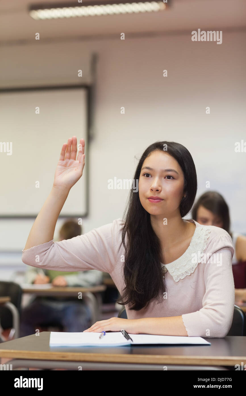 L'accent étudiant asiatique levant la main dans la classe Banque D'Images