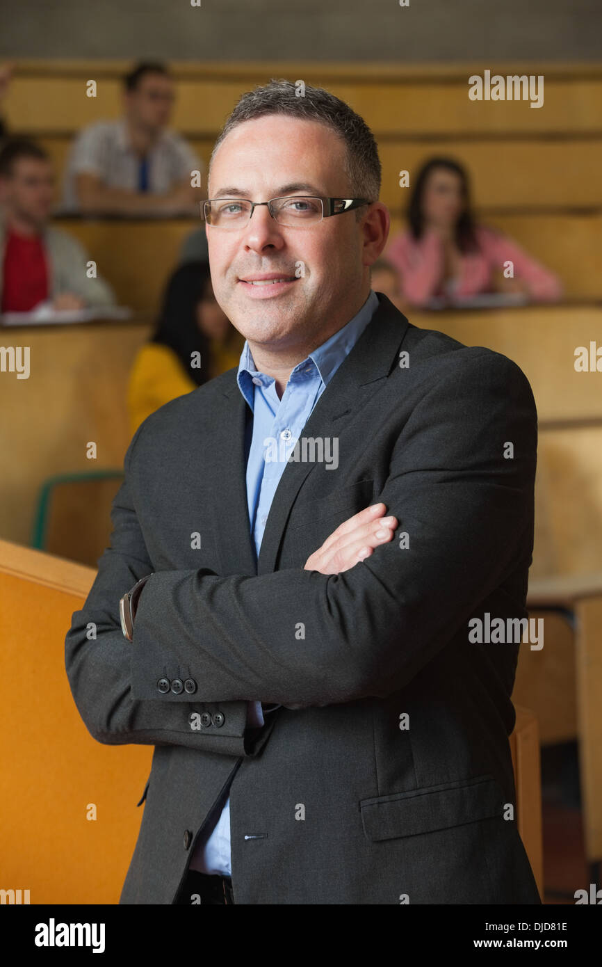 Maître smiling at camera en face de sa classe in lecture hall Banque D'Images