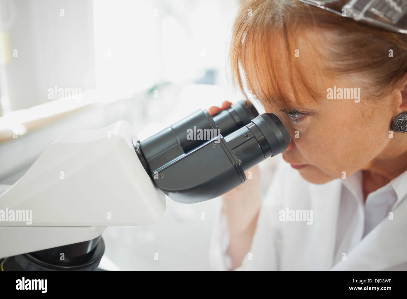 Close up of female scientist à la recherche à l'aide d'un microscope Banque D'Images