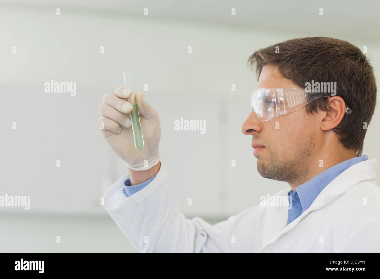 Voir le profil de beau mâle scientist looking at petit test tube Banque D'Images