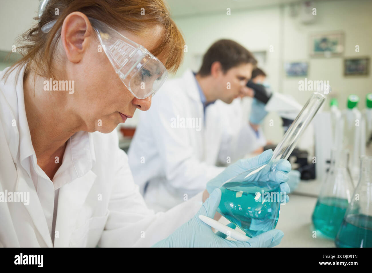 Femelle adulte à la recherche scientifique dans un erlenmeyer Banque D'Images