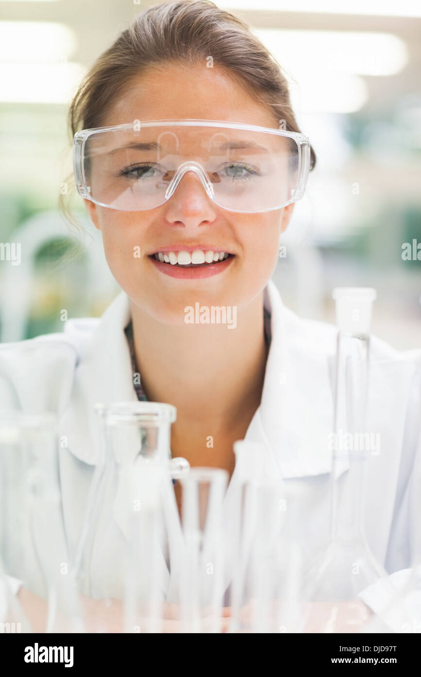 Smiling student wearing lunettes de sécurité en face de tubes à essai Banque D'Images