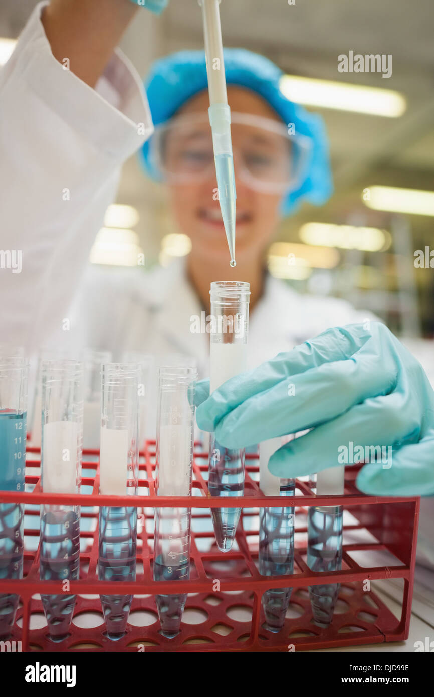 À l'aide d'étudiant holding test tube pipette avec liquide bleu Banque D'Images