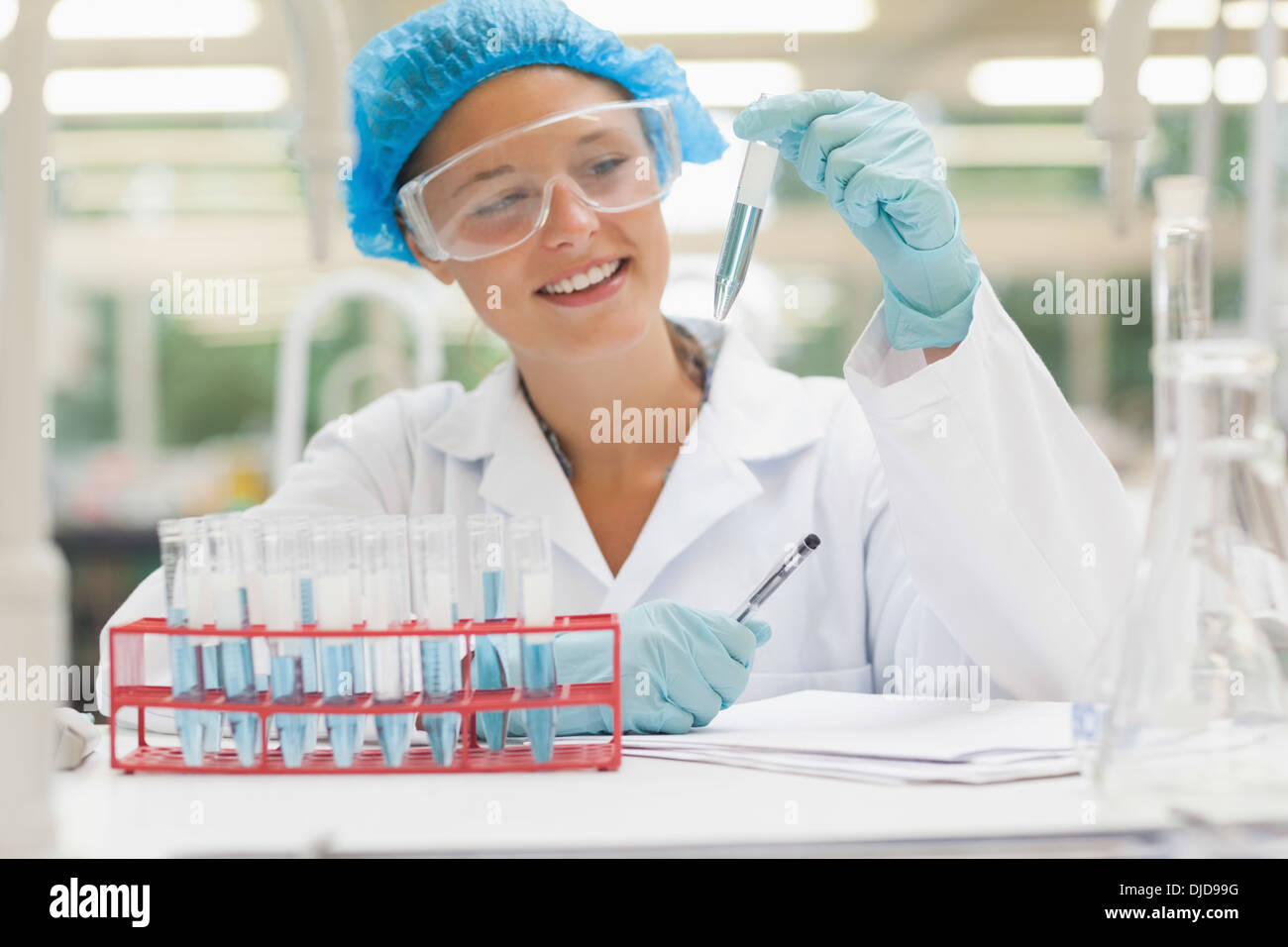 Smiling student holding test tube contenant du liquide Banque D'Images