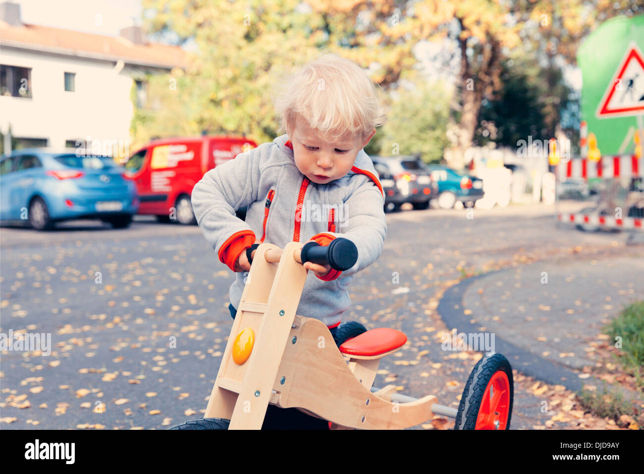 Allemagne, Bonn, petit garçon avec tricycle en bois Banque D'Images