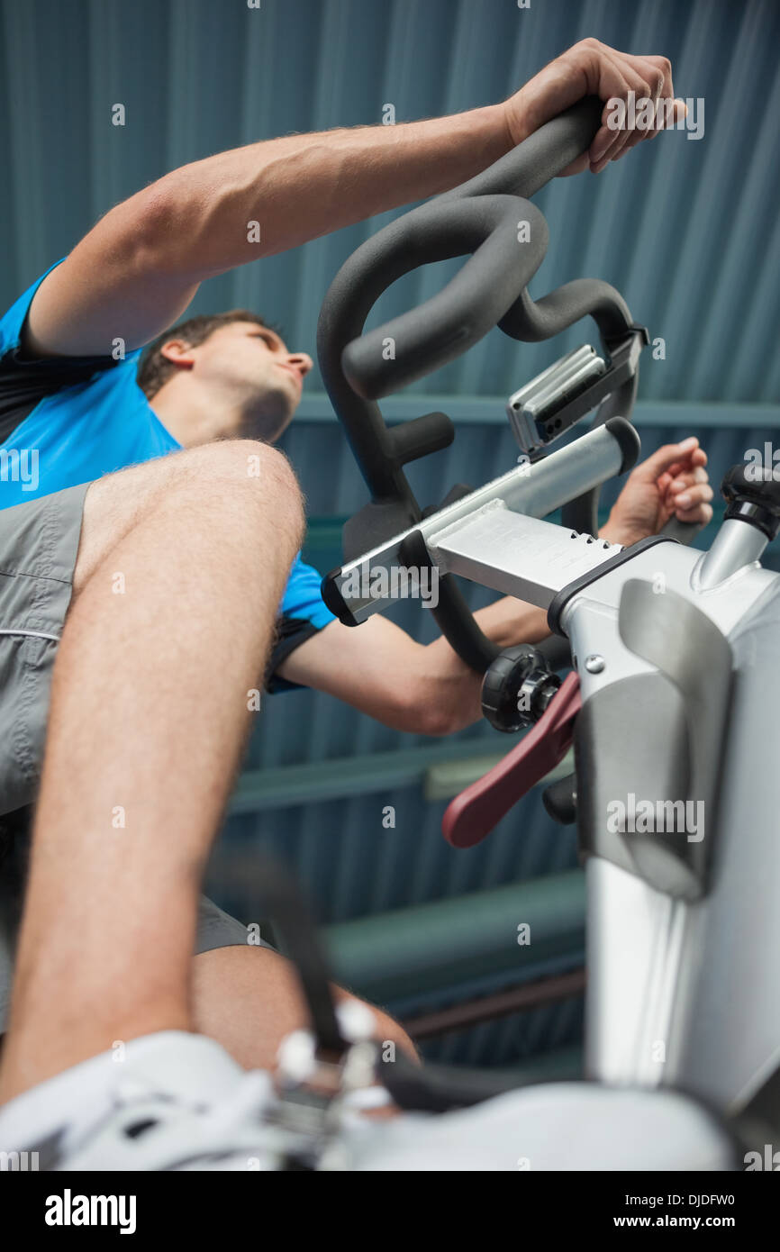 Homme déterminé working out at spinning class in gym Banque D'Images