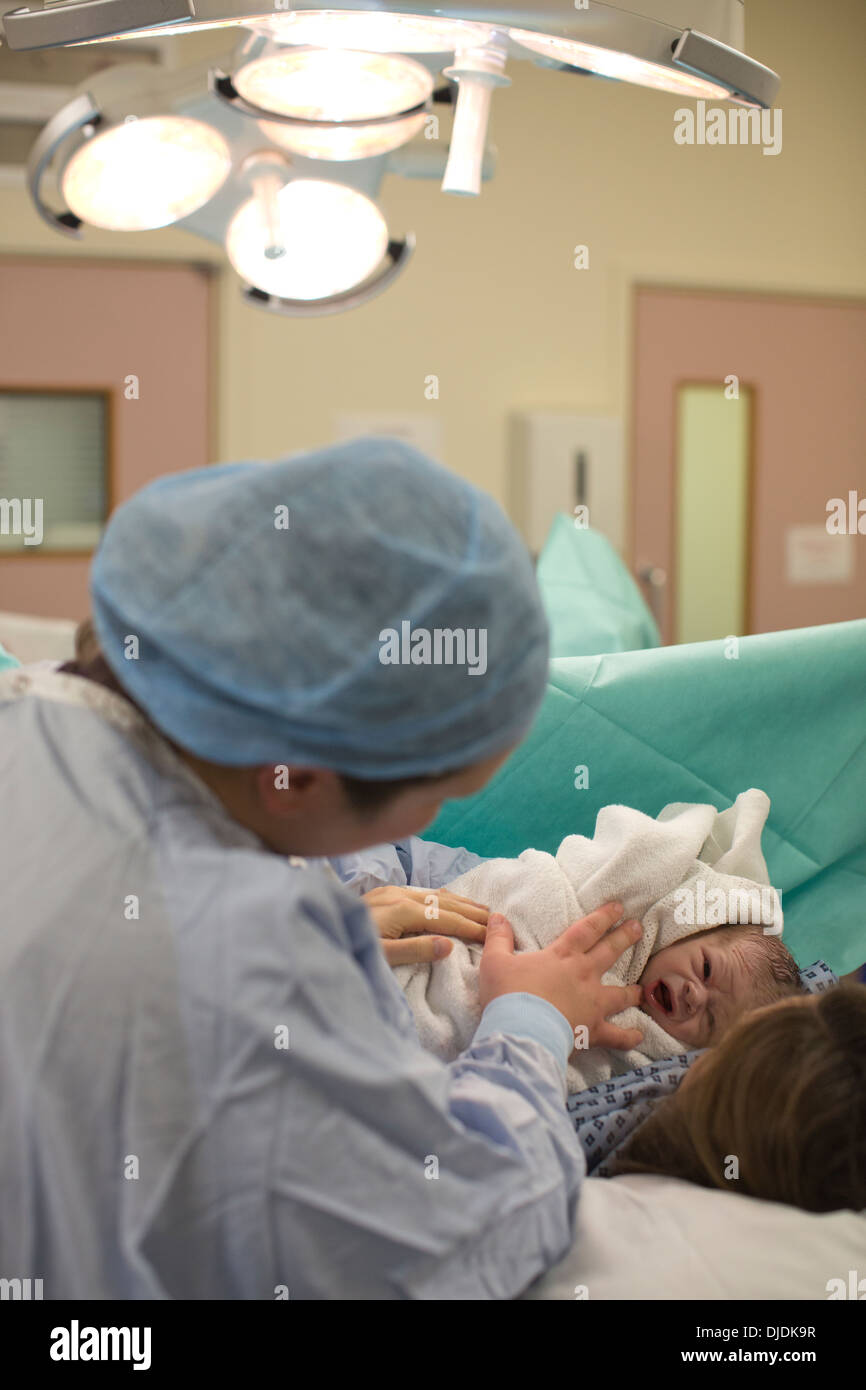 Bébé nouveau-né garçon d'être vérifié par des infirmières à l'hôpital théâtre de la maternité sur la salle de travail à l'hôpital, Kingston Upon Thames, Royaume-Uni Banque D'Images