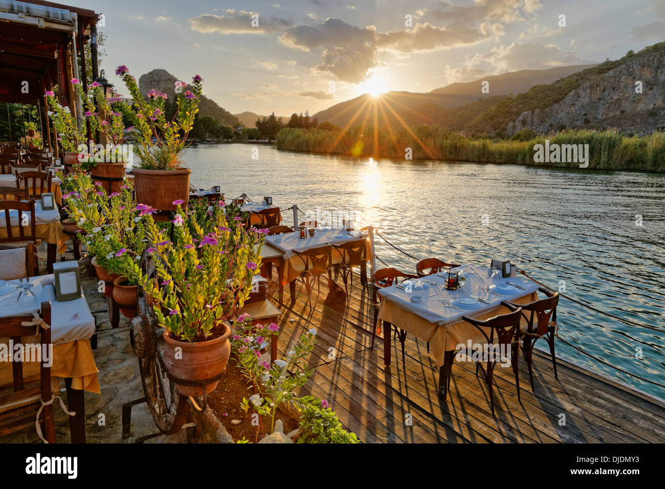 Coucher de soleil, set de tables dans un restaurant sur la rivière Dalyan, Dalyan, Muğla Province, Riviera turque ou Côte Turquoise, mer Egéé Banque D'Images