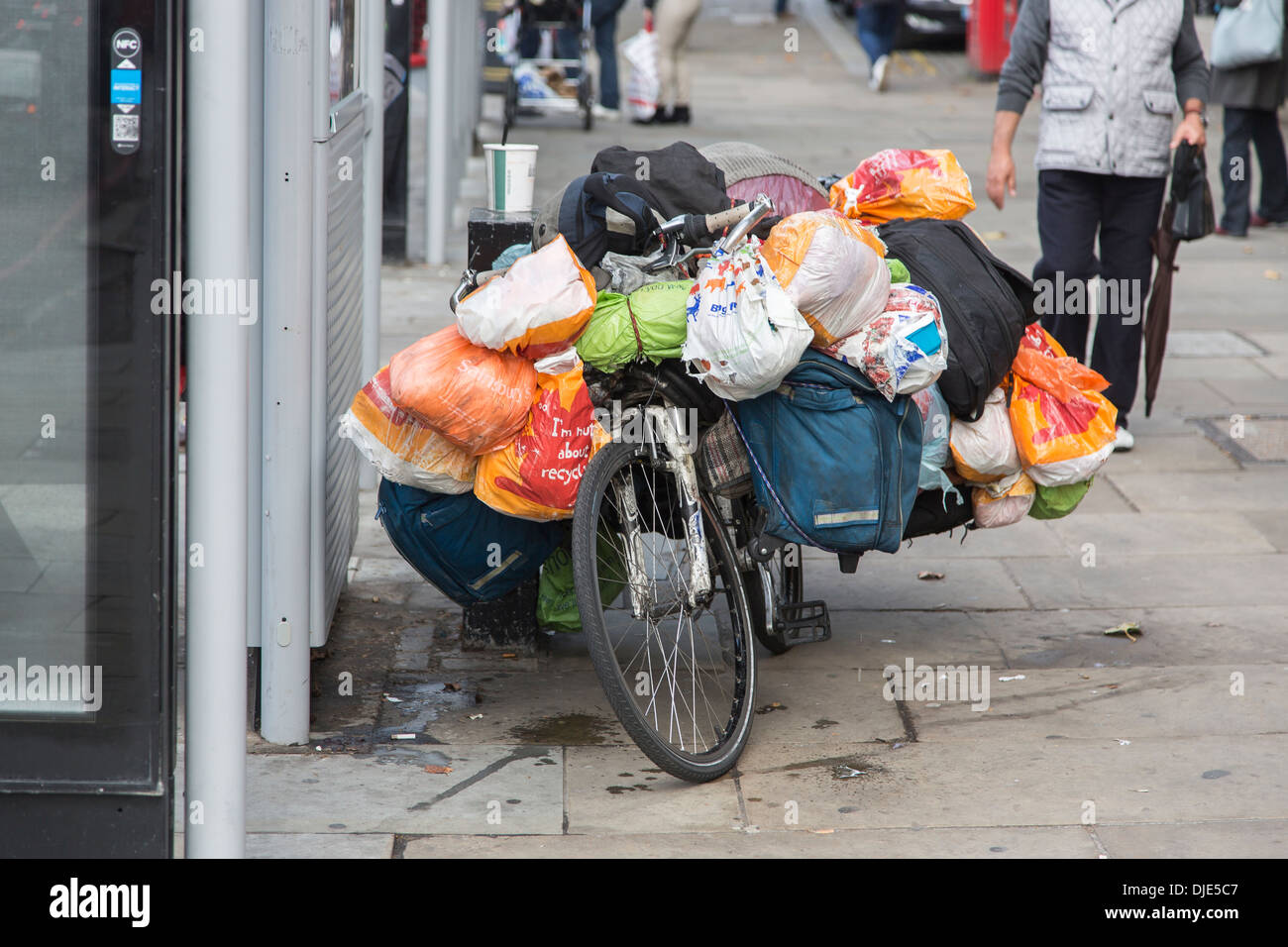 Location sur un trottoir dans le West End de Londres avec des biens d'un vagabond sans-abri dans des sacs de plastique Banque D'Images