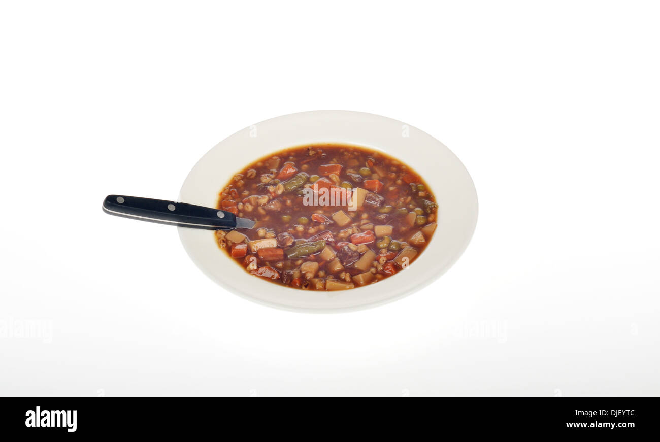 Bol de soupe boeuf et légumes avec cuillère sur fond blanc, découpe. USA Banque D'Images