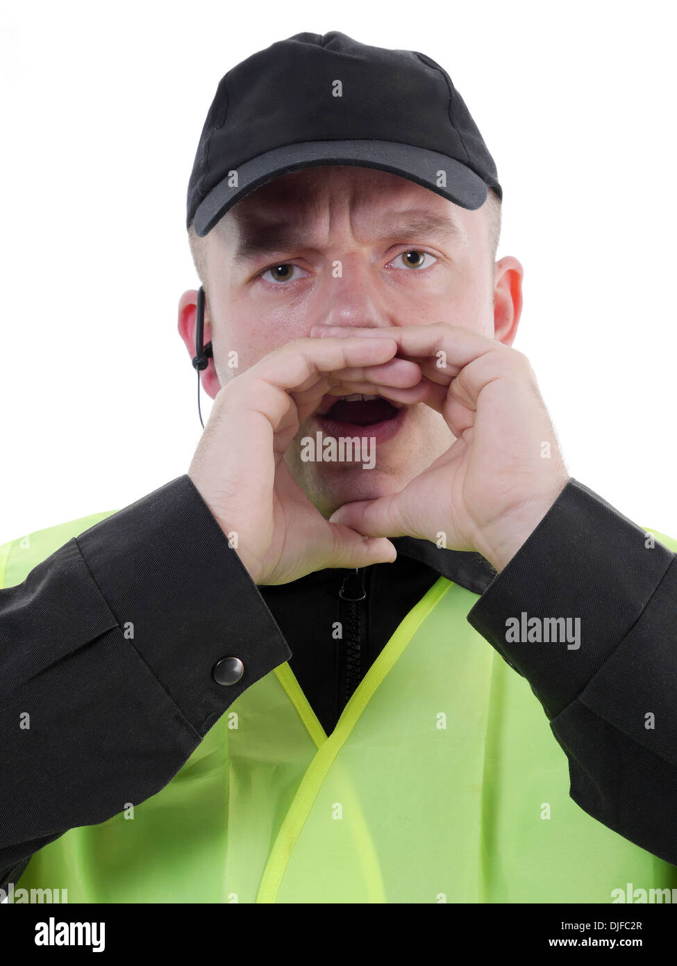 Policier portant un gilet réfléchissant jaune tenant les mains autour de sa bouche et l'appel Banque D'Images
