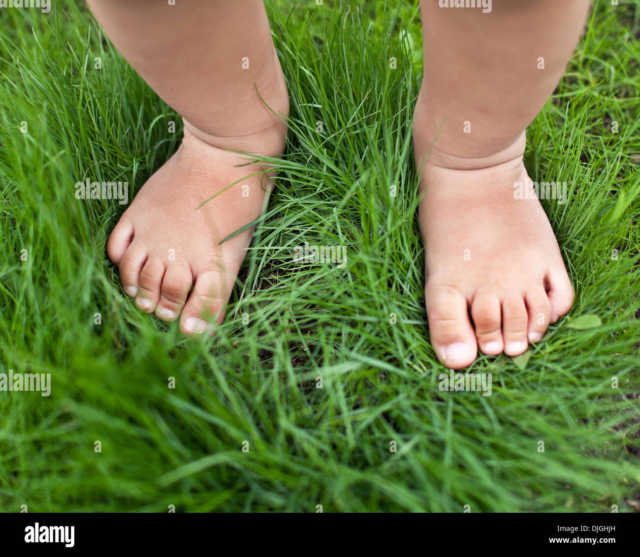 Petit bébé pieds sur l'herbe verte. Banque D'Images