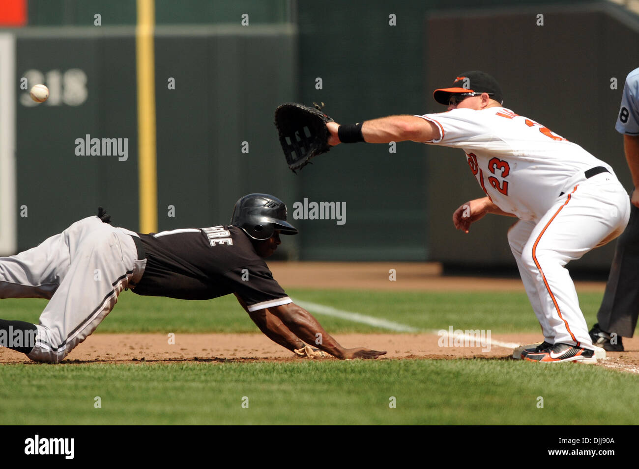 08 août 2010 - Baltimore, Maryland, États-Unis d'Amérique - Août 08, 2010 : Le joueur de premier but des orioles de Baltimore, Ty Wigginton (23) attend pour le jet comme voltigeur de gauche des Chicago White Sox Juan Pierre (1) plongées en toute sécurité en premier lors de la cinquième manche du match de dimanche après-midi à Camden Yards de Baltimore, MD. Score à égalité 1 à 5 manches...crédit obligatoire : Russell Trac Banque D'Images