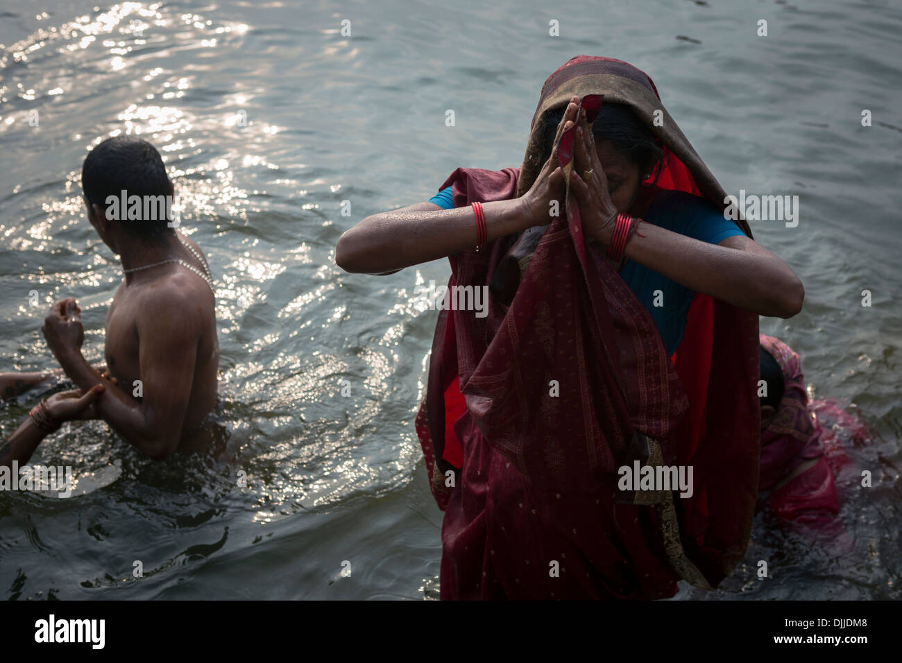 Les croyants hindous prier à l'aube submergé dans les eaux du Gange, un fleuve sacré dans la religion hindoue. Banque D'Images