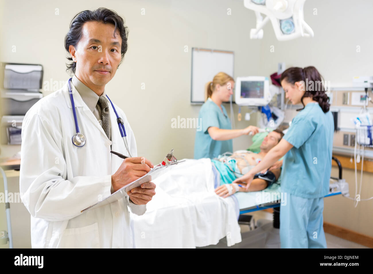 Doctor Holding Clipboard Examining patient avec les infirmières Banque D'Images