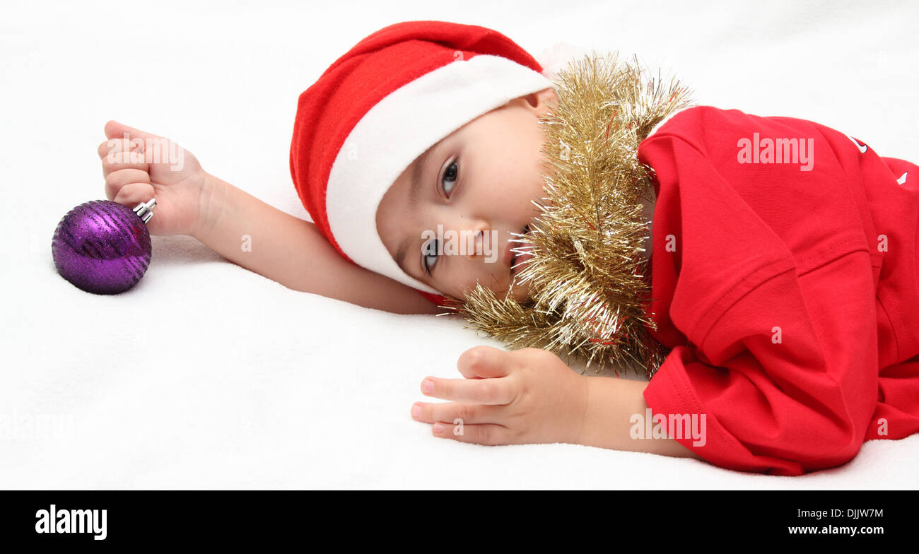 Enfant dans santa claus hat se trouve sur le lit Banque D'Images