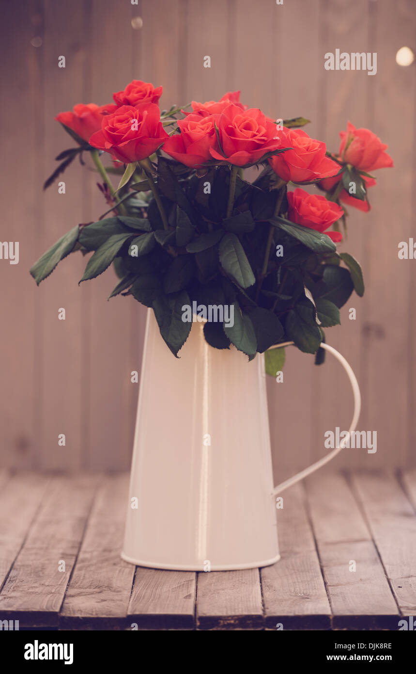 Fleurs dans un vase sur un fond de bois Banque D'Images