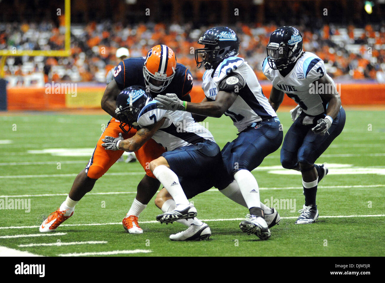 19 septembre 2010 - Syracuse, New York, United States of America - Syracuse running back Orange Delone Carter (3) tient le coup du Maine l'ours noir Dominic évoluait Cusano (7) près de la ligne latérale au deuxième trimestre comme le Maine l'ours noir s'attaquer défensive Douglas Alston (91) et du Maine l'ours noir Trevor évoluait Coston (3) fermer dans pour aider à faire d'aborder. Principale défait Syracuse Banque D'Images