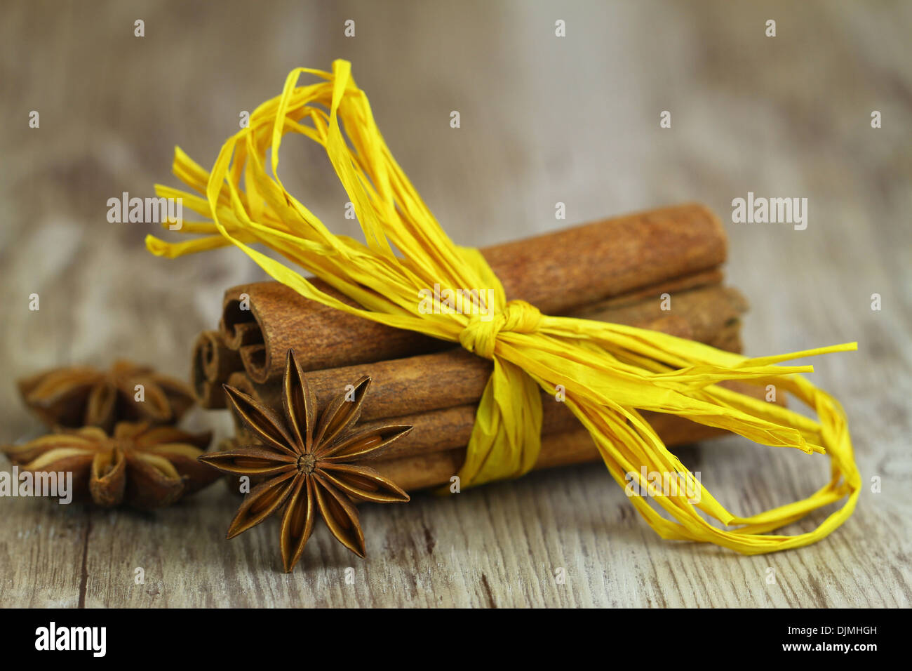 L'anis étoilé appuyé contre des bâtons de cannelle attaché avec du ruban jaune string Banque D'Images