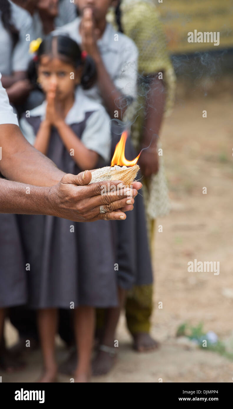 L'homme de l'Inde rurale faire aarthi avec le feu et la noix de coco lors d'une puja à Sathya Sai Baba l'hôpital d'approche mobile service. L'Andhra Pradesh, Inde Banque D'Images