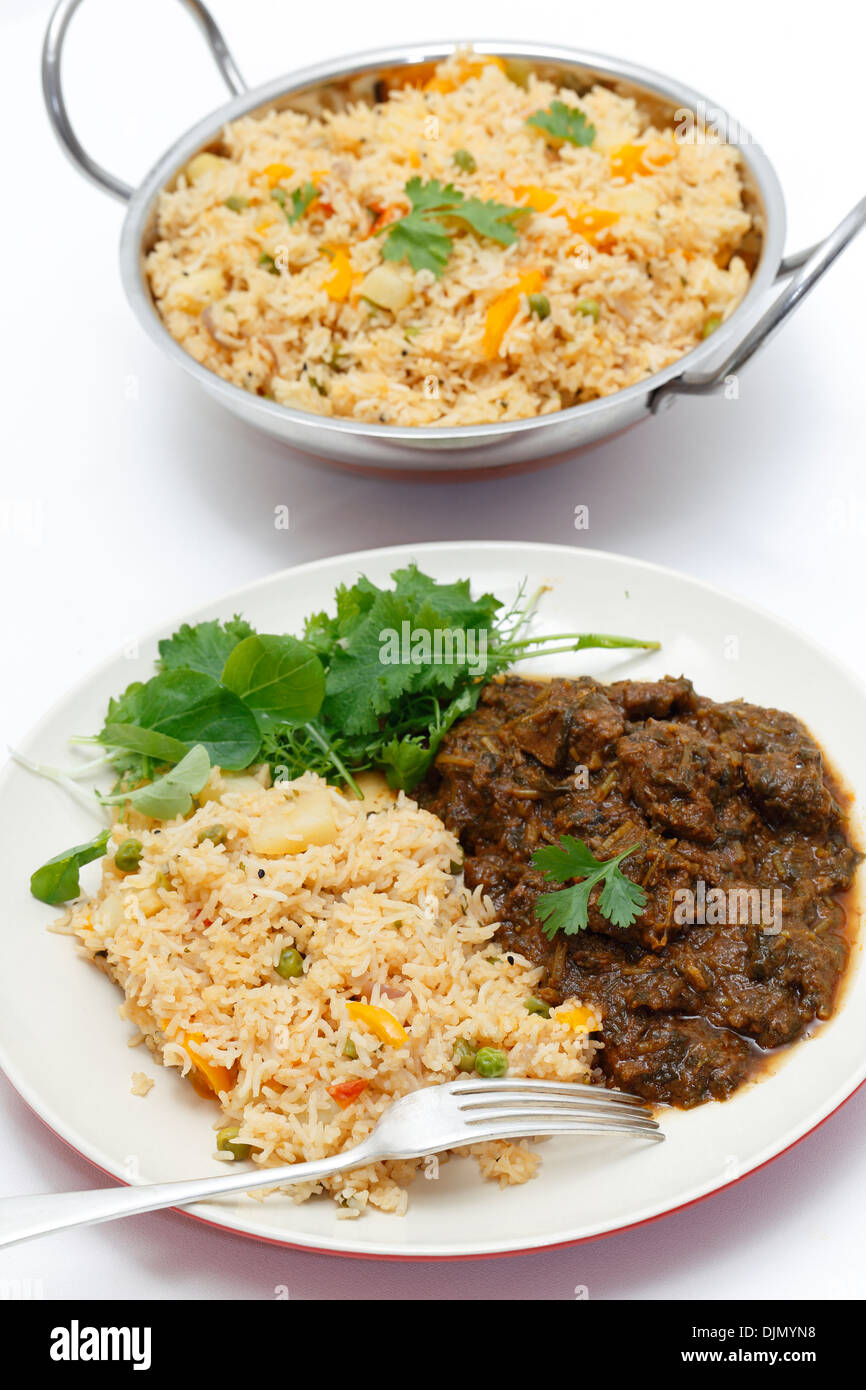 Le Methi gosht agneau, fenugrec ou servi avec tomate (thakkali) et une salade de légumes biryani, avec un kadai du riz derrière Banque D'Images