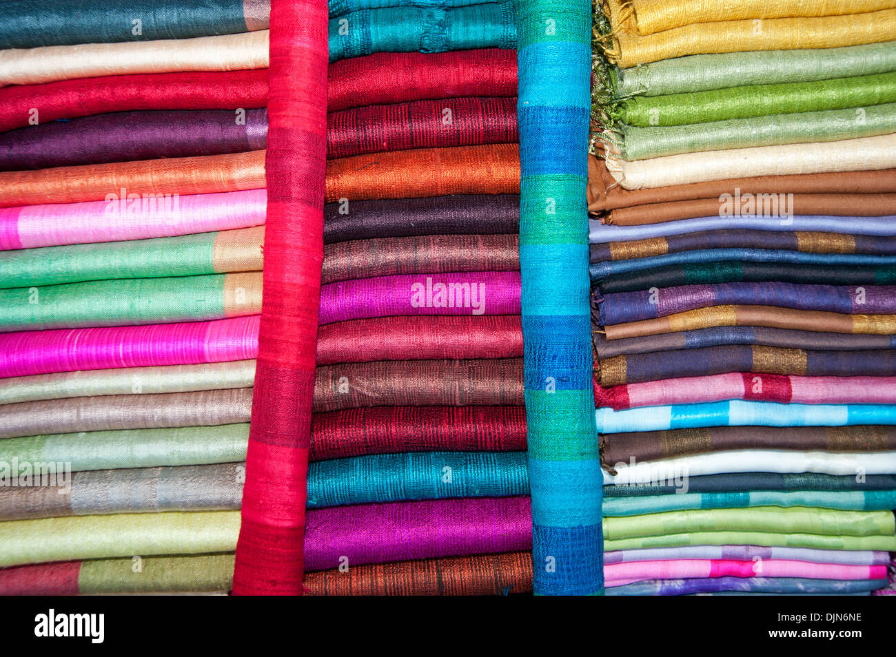 Détails de rangées de soies multicolores et tissus sur un étal de marché à Luang Prabang au Laos Banque D'Images