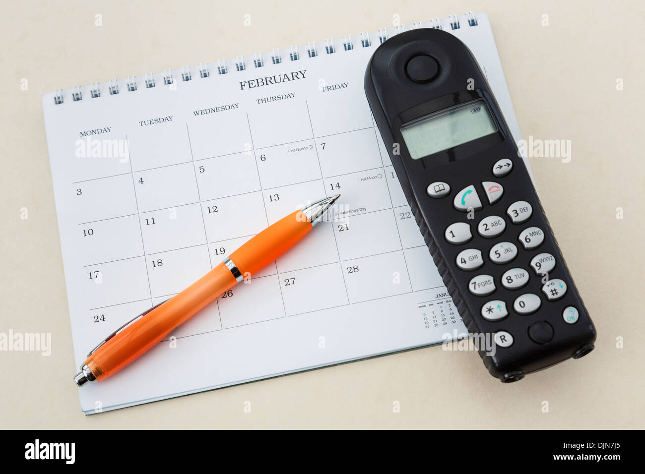 Téléphone sans fil combiné avec un calendrier 2014 vierge et un stylo pointant vers la Saint-Valentin le 14 février Banque D'Images