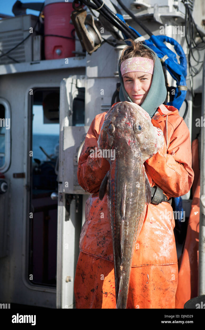 Claire Laukitis tenant une morue du Pacifique lors de la pêche commerciale pour le flétan du Pacifique dans la région de Morzhovoi Bay Banque D'Images