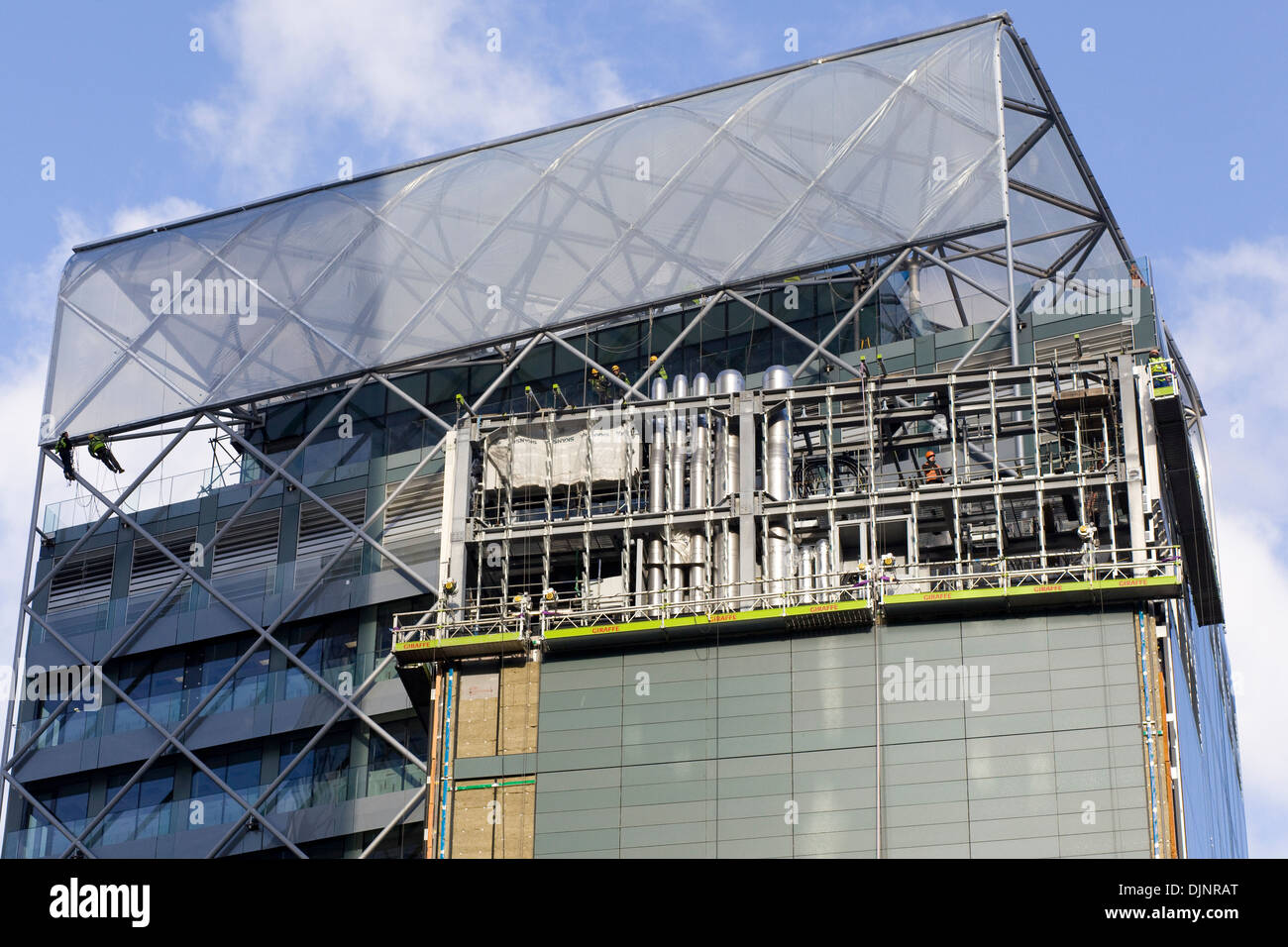 Les hommes qui travaillent sur un gratte-ciel de verre à Londres en Angleterre Banque D'Images