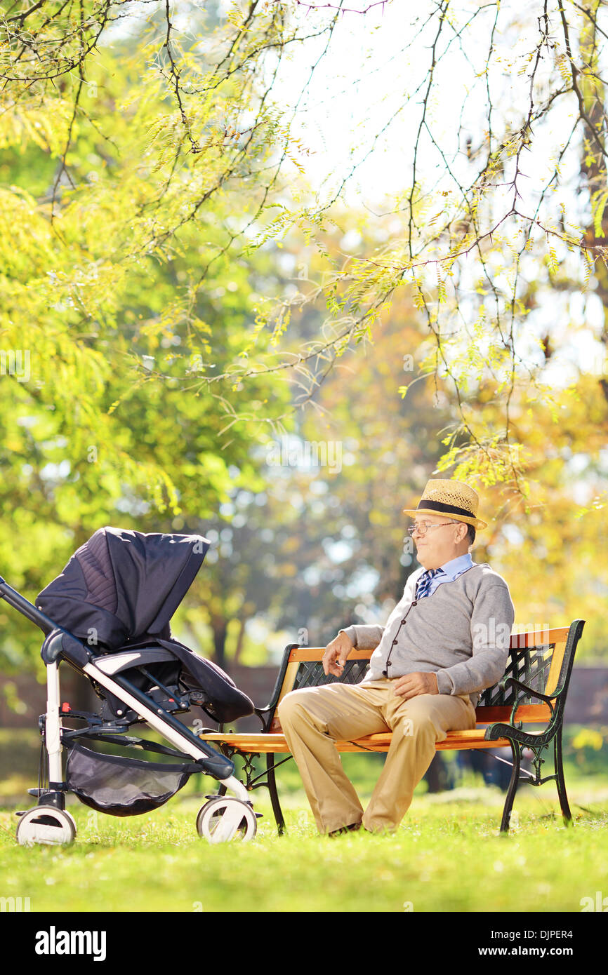 Hauts homme assis sur un banc et en regardant son neveu dans une poussette de bébé Banque D'Images