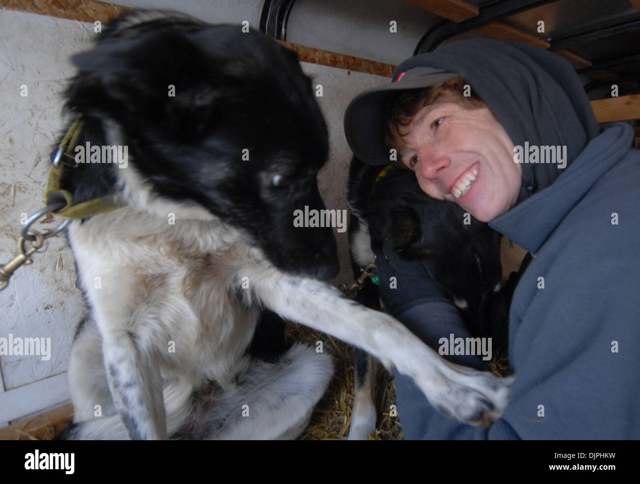 Mar 07, 2010 - Willow, Alaska, USA - Iditarod rookie PAT LUNE, 33, de Chicago hugs son chien que du bois d'Hera, gauche, place une patte sur lui pendant le redémarrage à Willow le dimanche. Moon a décidé de suivre son rêve de gérer les 1 000 milles de course de chiens de traîneau et a retardé son traitement pour lympphoma non hodgkinien, un cancer du sang, et s'occupe de la colite ulcéreuse, qui ca Banque D'Images