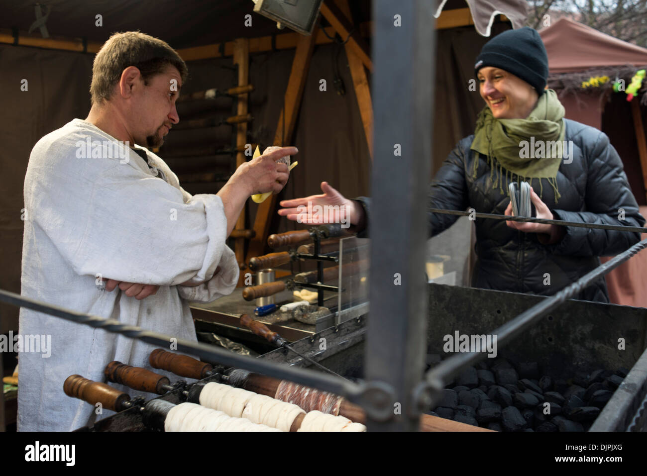 Une femme achète delicious trdelník à un blocage de rue. L'un des bonbons sont trdelník Prague. Certains petits gâteaux roulés et creux. Banque D'Images