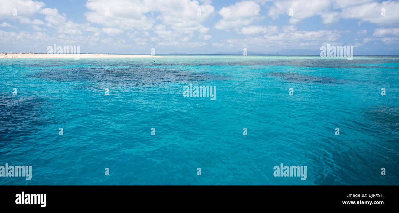 Vue sur la mer de Corail sur une journée ensoleillée avec des nuages dans le ciel, au large de la côte du nord tropical du Queensland, Australie Banque D'Images