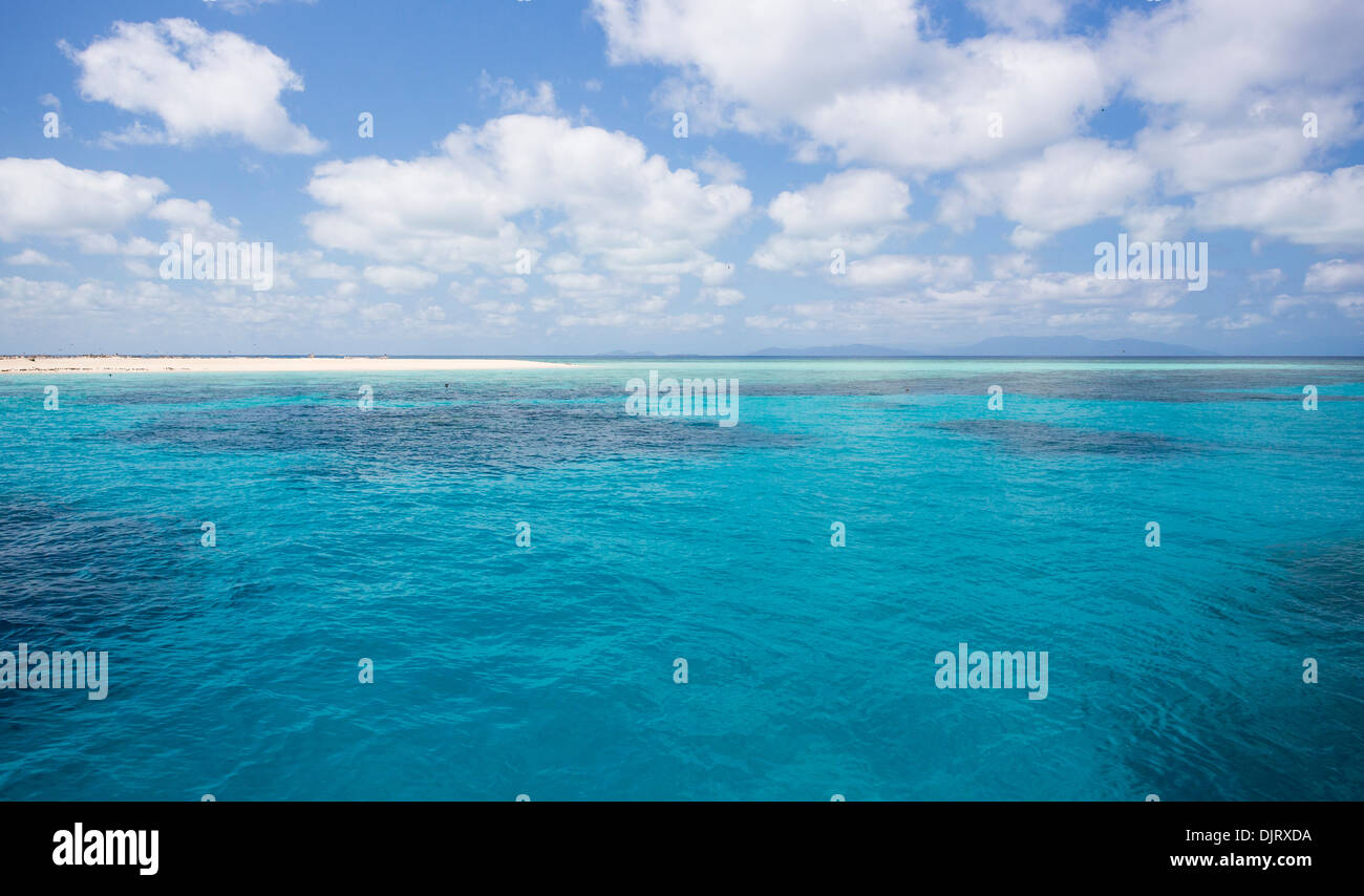 Vue sur la mer de Corail sur une journée ensoleillée avec des nuages dans le ciel, au large de la côte du nord tropical du Queensland, Australie Banque D'Images